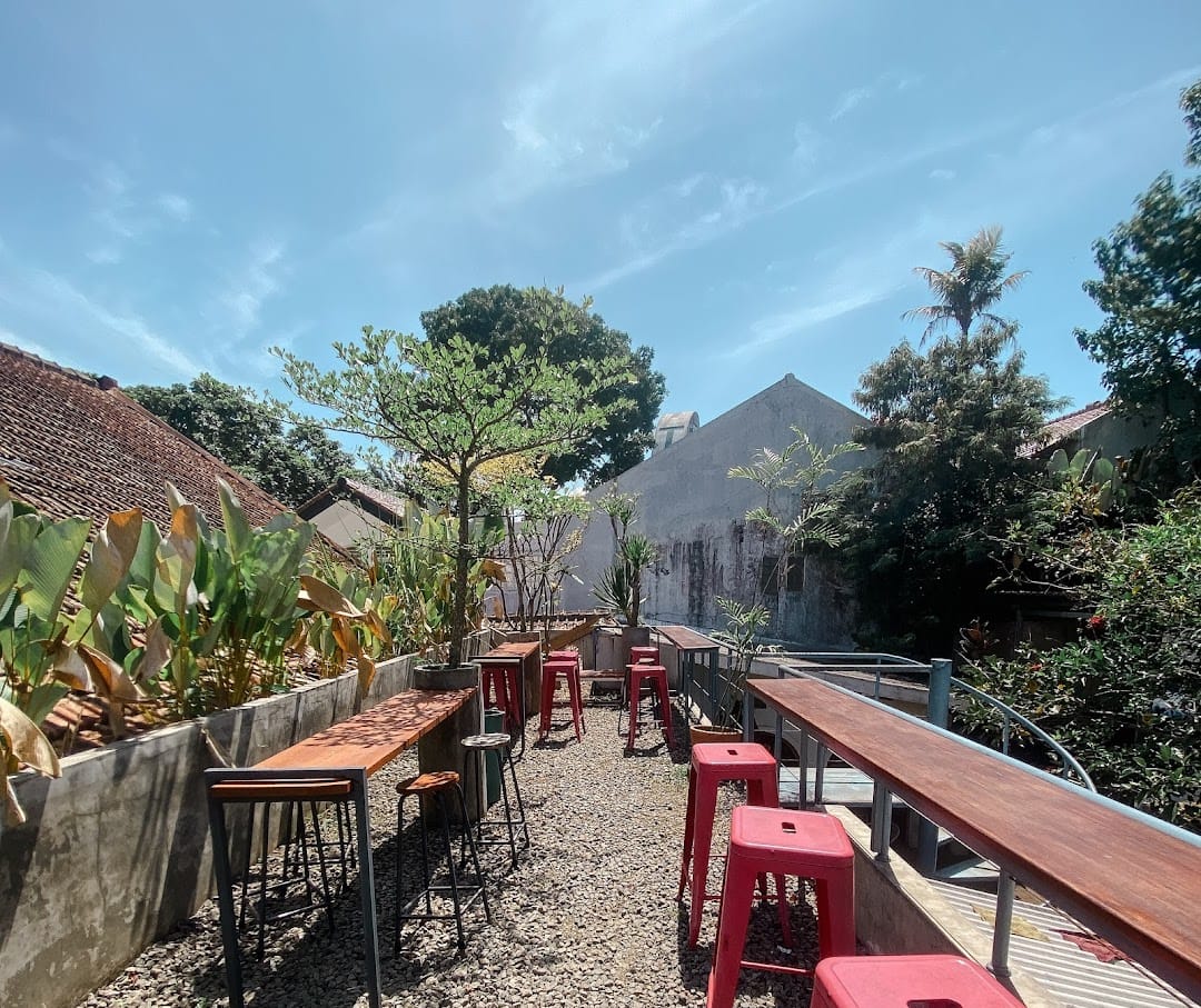 Courtyard with red metal stools, palms, blue sky